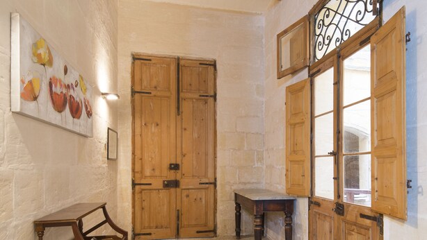 Una habitación con puerta de madera, una mesita y una silla.