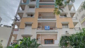 A multi-story hotel with balconies, a sign indicating it is a hotel, and a gated entrance. - Khyathi Hotels (Hyderabad)