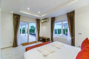 Hotellihuone, jossa on sänky, työpöytä ja näkymä ulos.