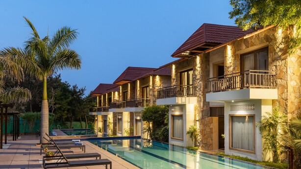 A hotel with a swimming pool, multiple balconies, and stone facades. - Ramya Resort & Spa (Udaipur)