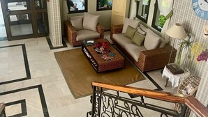 A spacious living area with a sofa set, a coffee table, and a staircase with a railing. - Carikci Hotel - + 16 Adult"s Only  (Marmaris)