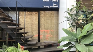 Een modern gebouw met een bord waarop staat: Bed in Town Chiang Mai.