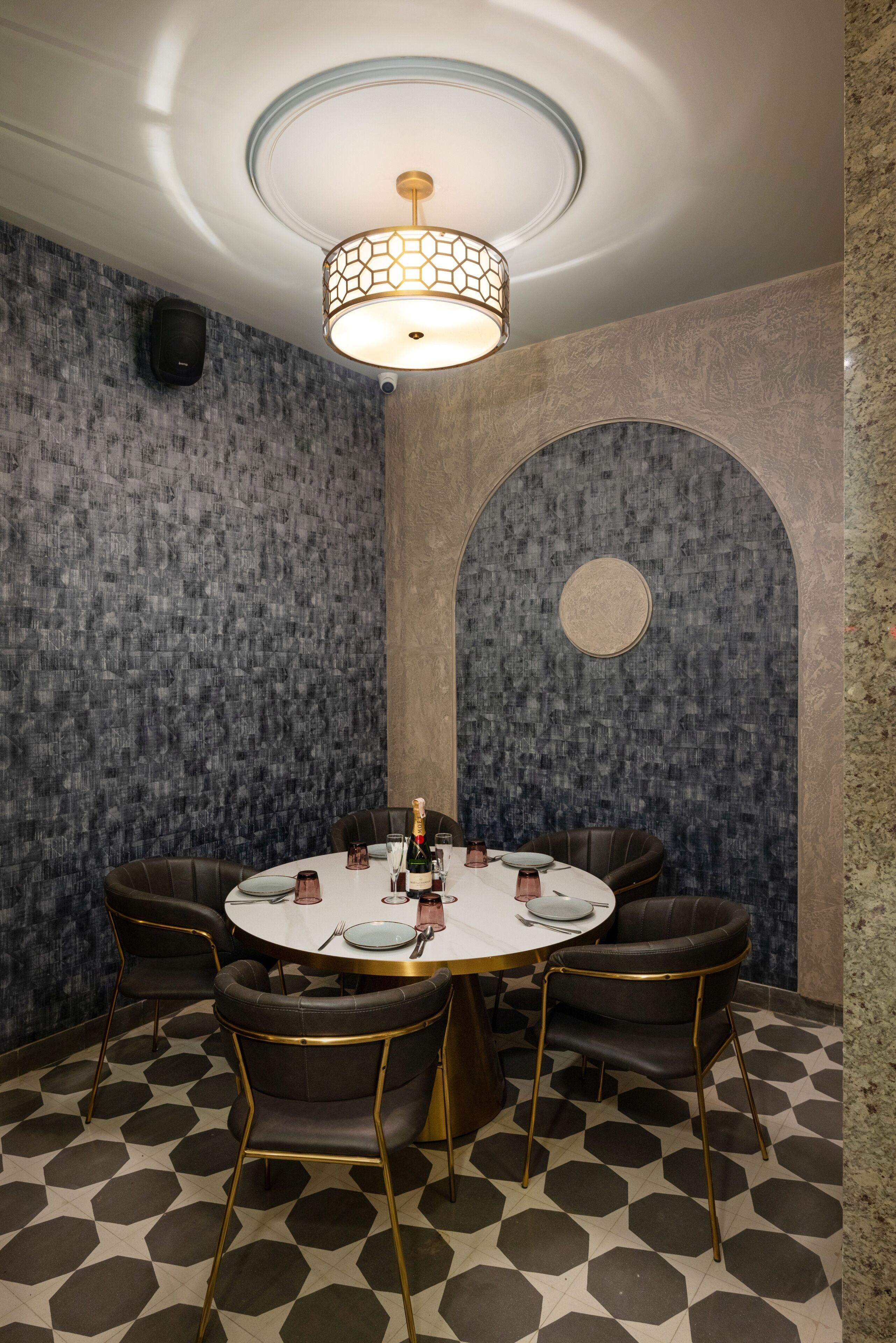 A conference room with a round table, six chairs, and a chandelier.