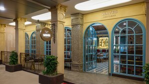 A restaurant named 'Waves Restobar' with a checkered floor, blue-framed windows, and a red carpet leading to the entrance. - Freesia By Express Inn (Mumbai)