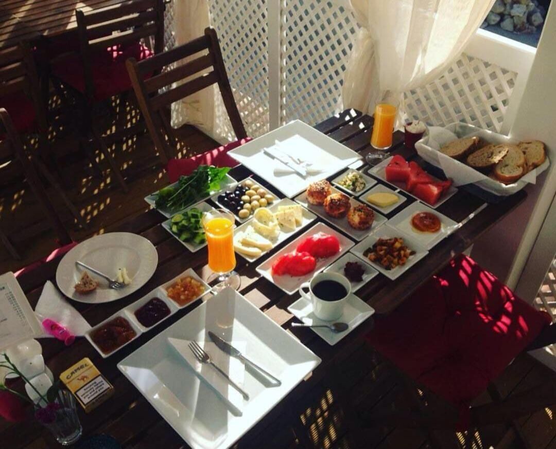 A breakfast table with various food items and a cup of coffee.
