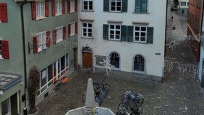 A courtyard with a fountain, cobblestone pavement, and buildings with traditional architecture. - Hotel Zunfthaus zur Rebleuten (Chur)