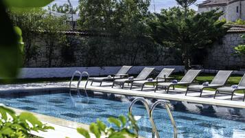 Piscine extérieure, parasols de plage, chaises longues