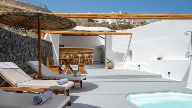 Área de piscina ao ar livre iluminada pelo sol, com espreguiçadeiras e uma pérgola de madeira.