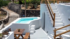 Área de piscina no terraço com escada de madeira e uma pequena mesa.