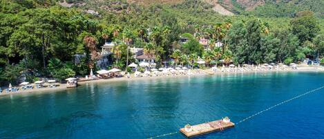 Privat strand, vit sandstrand, solstolar och parasoller