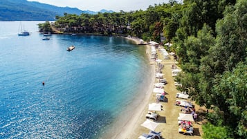 Playa privada, arena blanca, sillas reclinables de playa, sombrillas