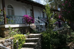 Una escalera de piedra que lleva a un edificio blanco con ventanas de arco y un balcón.