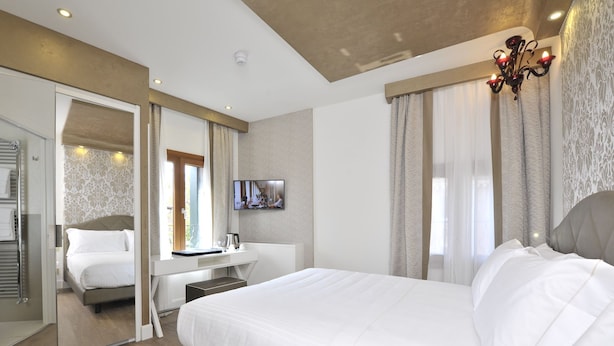 Une chambre d’hôtel moderne avec un grand lit, un bureau et une télévision.