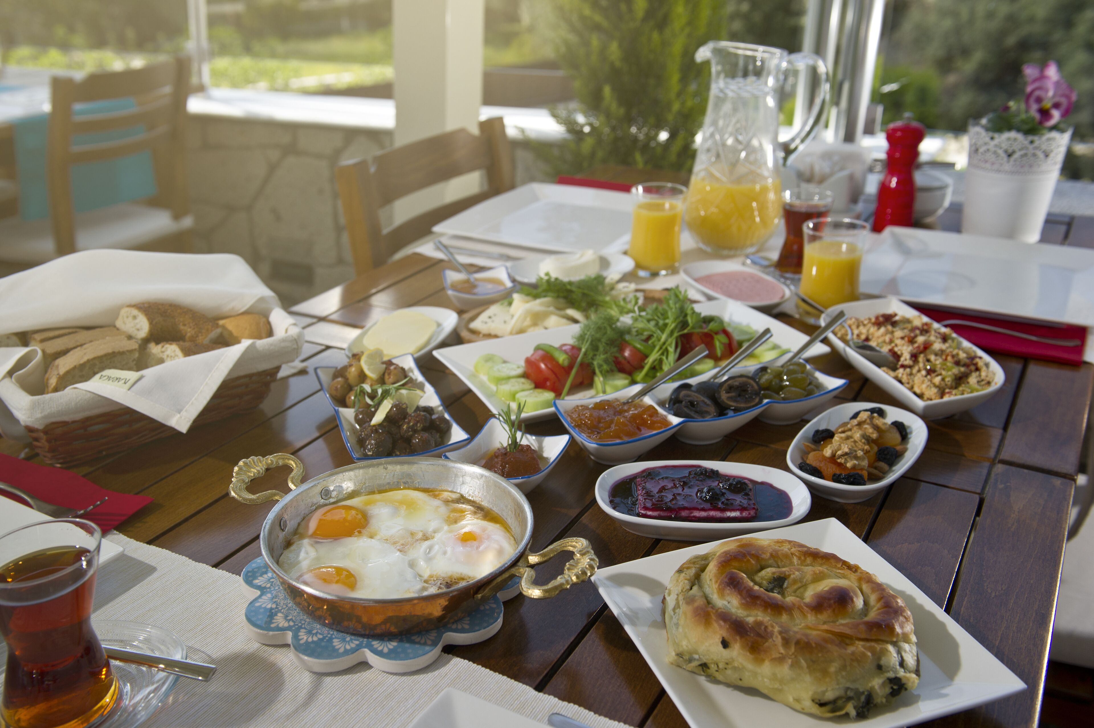 A breakfast table with various dishes, including eggs, bread, and fruit.