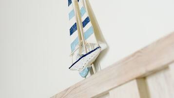 A wooden railing with a small sailboat model hanging from it.