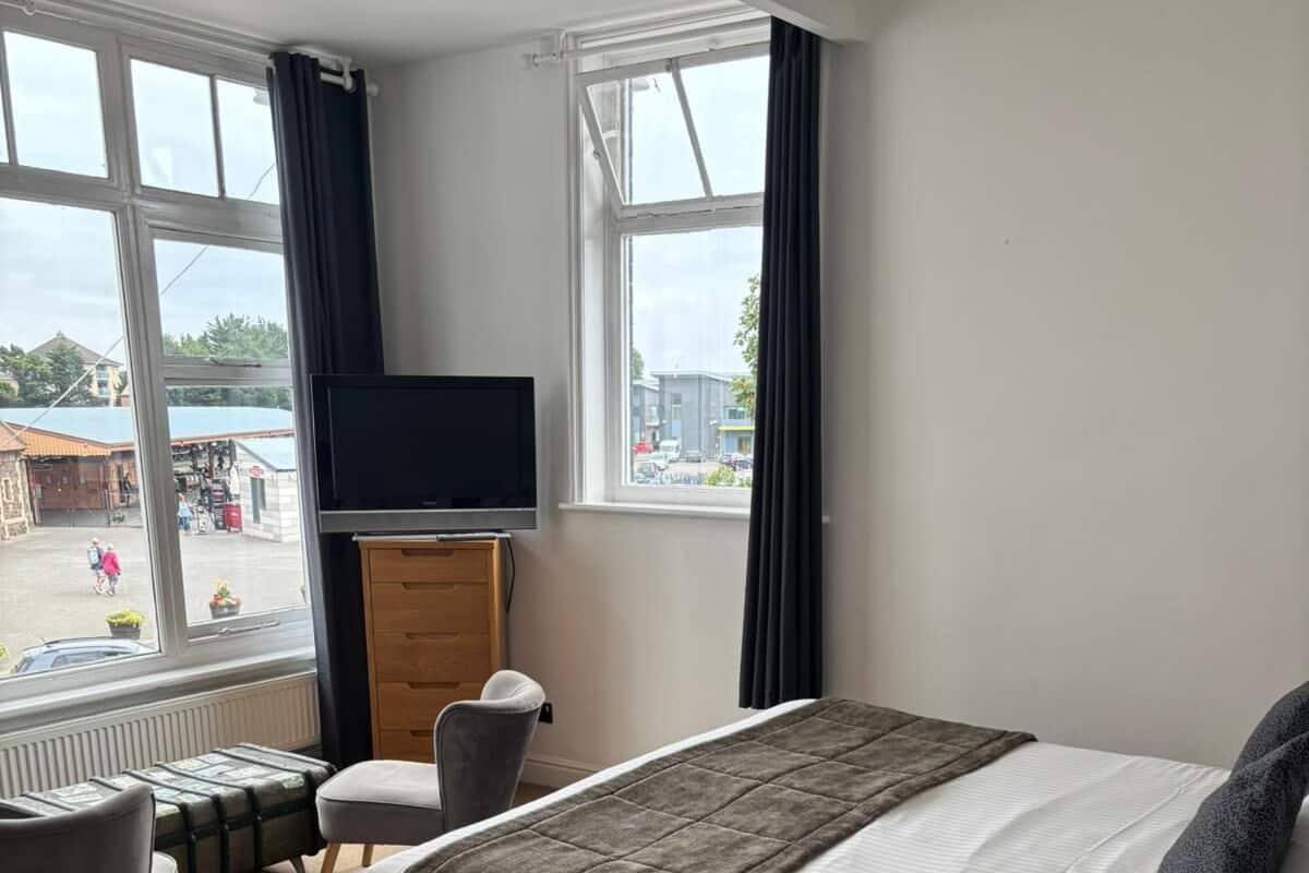 A hotel room with a bed, a TV, a desk, and a chair.