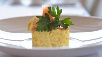 Un plato blanco con un pedazo de comida adornado con perejil y una rodaja de naranja.