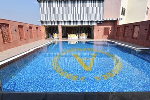 A swimming pool with a geometric pattern and a central design.