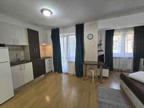 A compact living space with a kitchenette, a dining area, and a bed. - Decebal Residence Apartments (Bucharest)