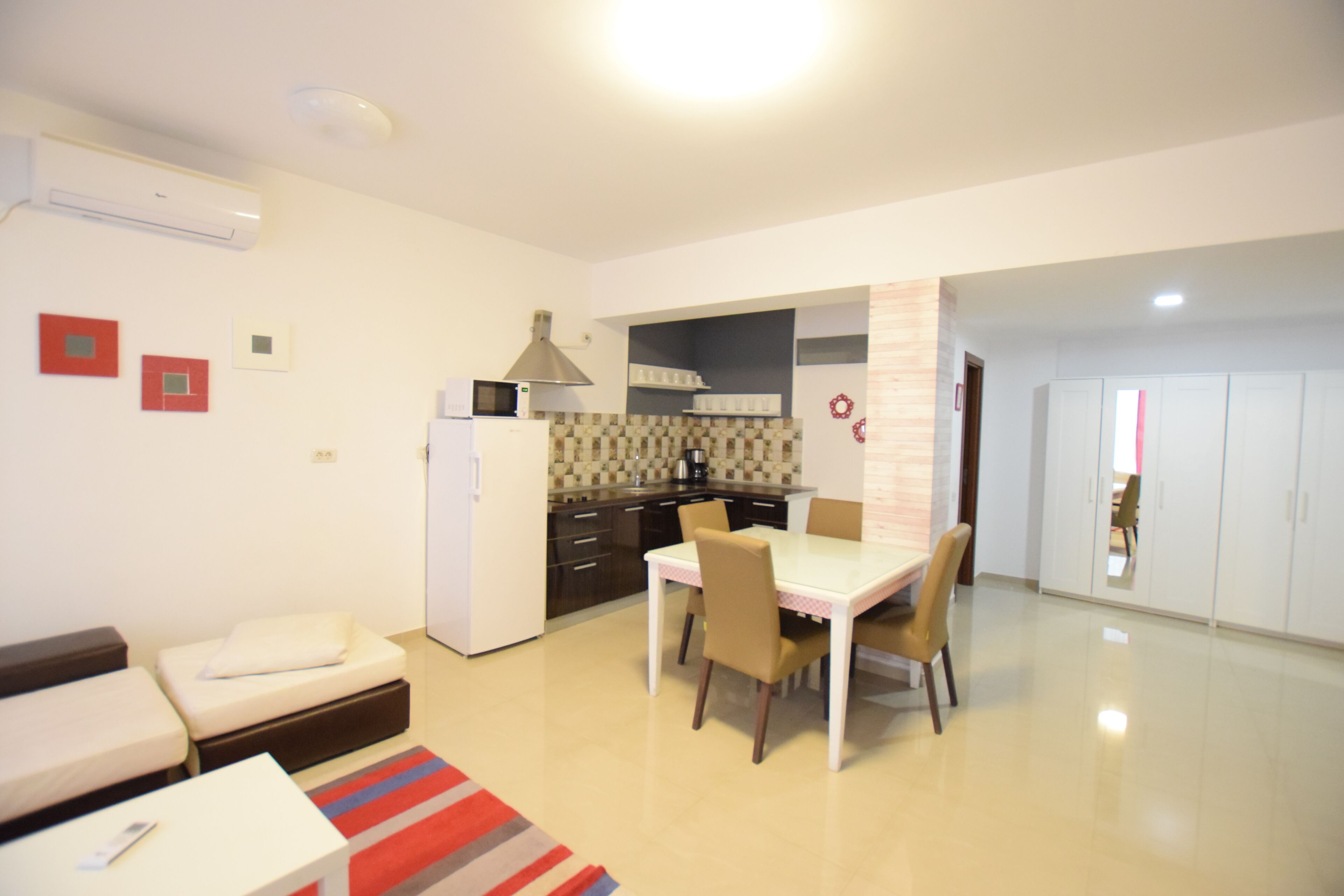 A modern kitchen with a microwave, stove, and cabinets. There is a dining area with a table and chairs.