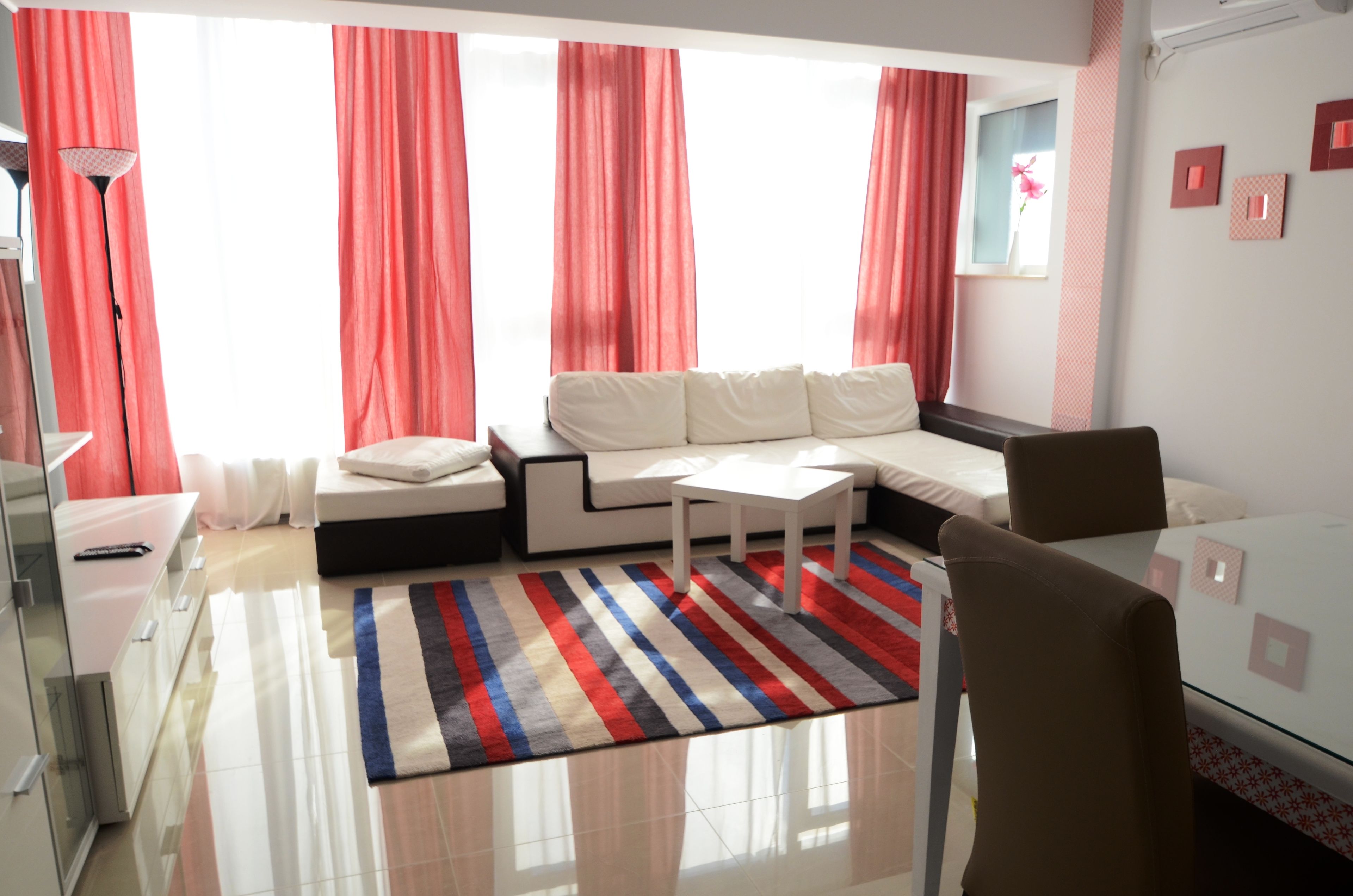 Una sala de estar moderna con un sofá, una mesa de centro y un aparador de vidrio.
