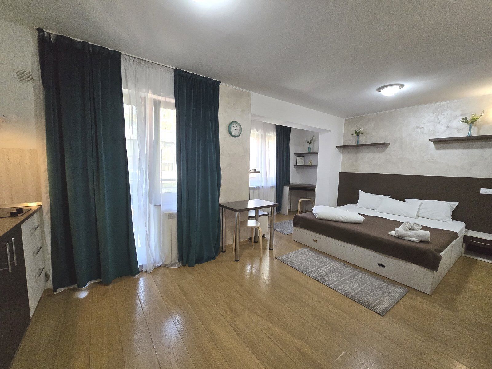 A modern hotel room with a bed, a desk, and a chair.