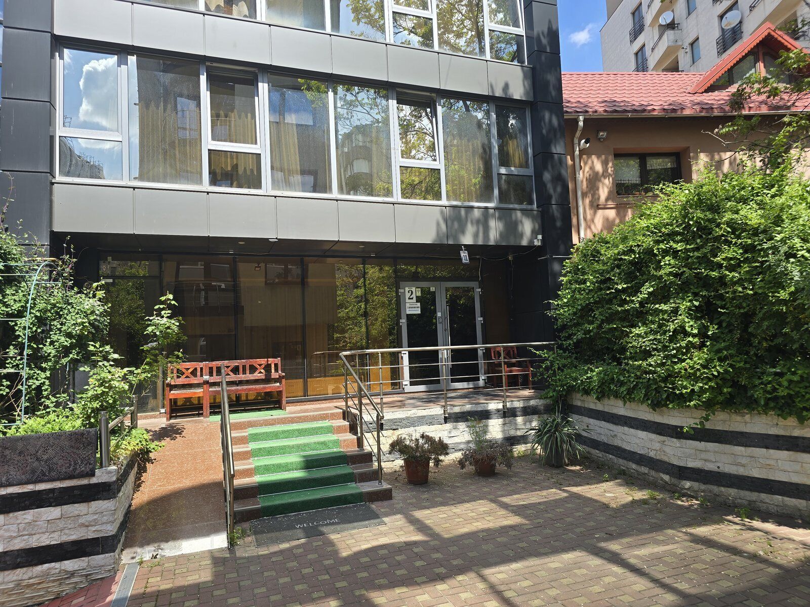 Un bâtiment moderne avec un escalier menant à une porte portant le numéro « 2 ».