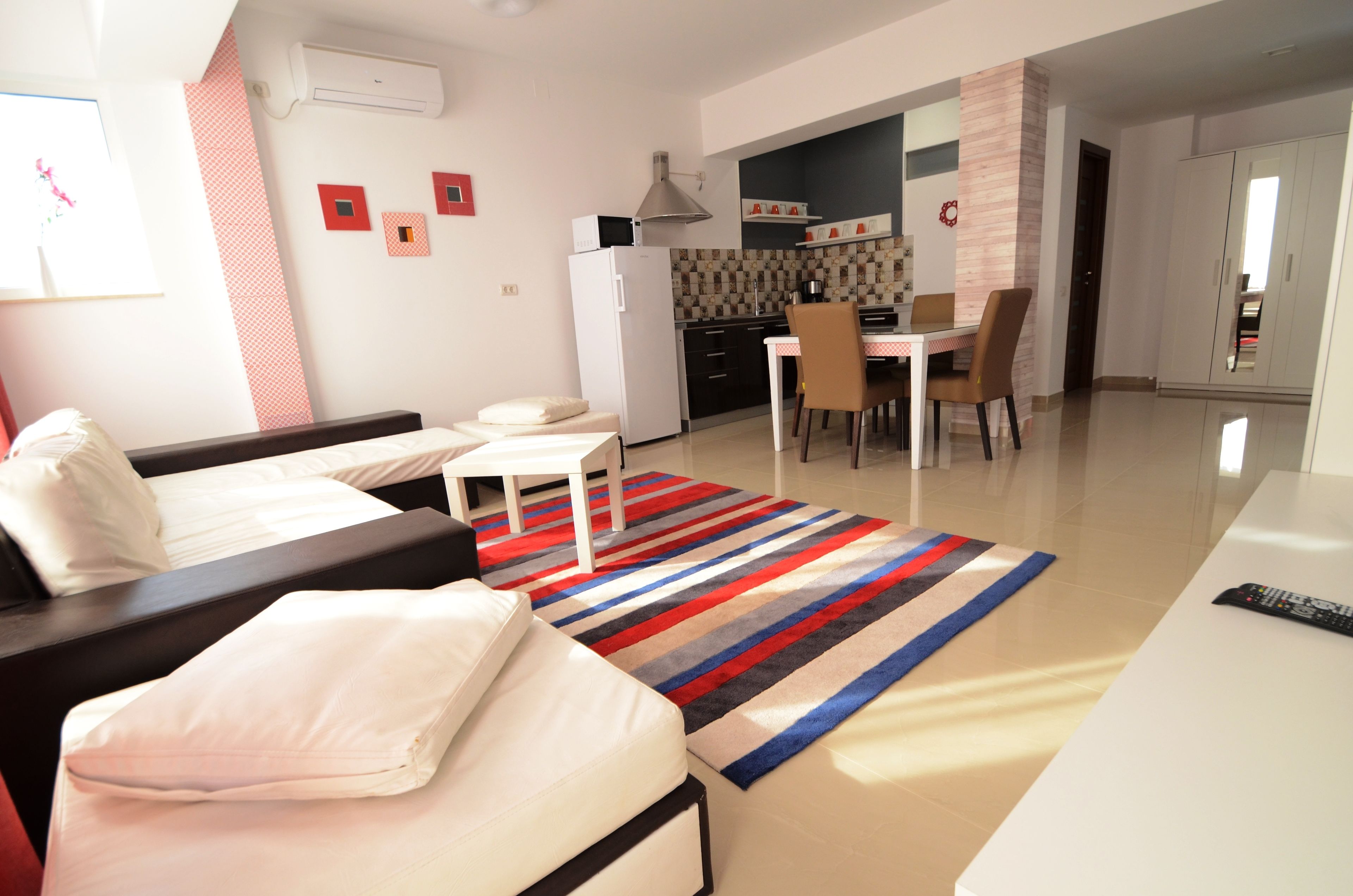A modern apartment with a living area, kitchen, and dining space.