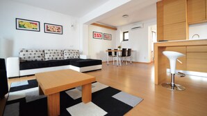 Un salon moderne comprenant un canapé, une table basse et un coin repas avec des chaises et une table.