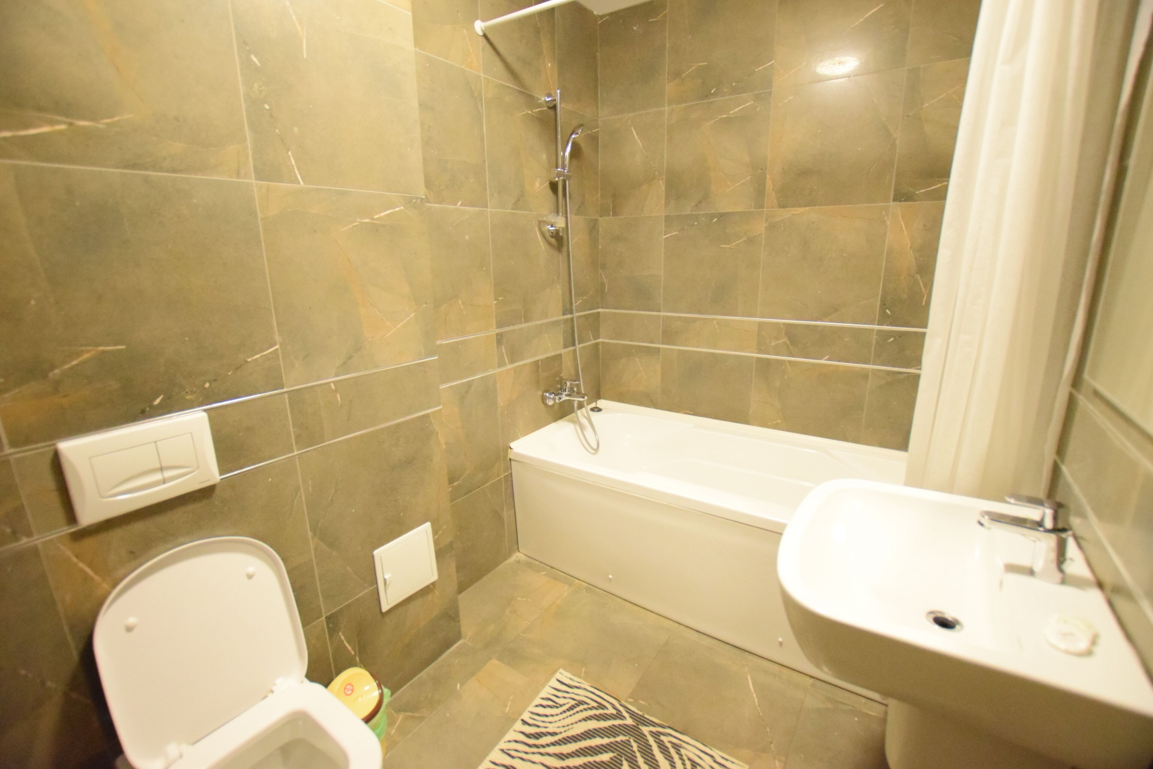 A bathroom with a toilet, bathtub, and sink.