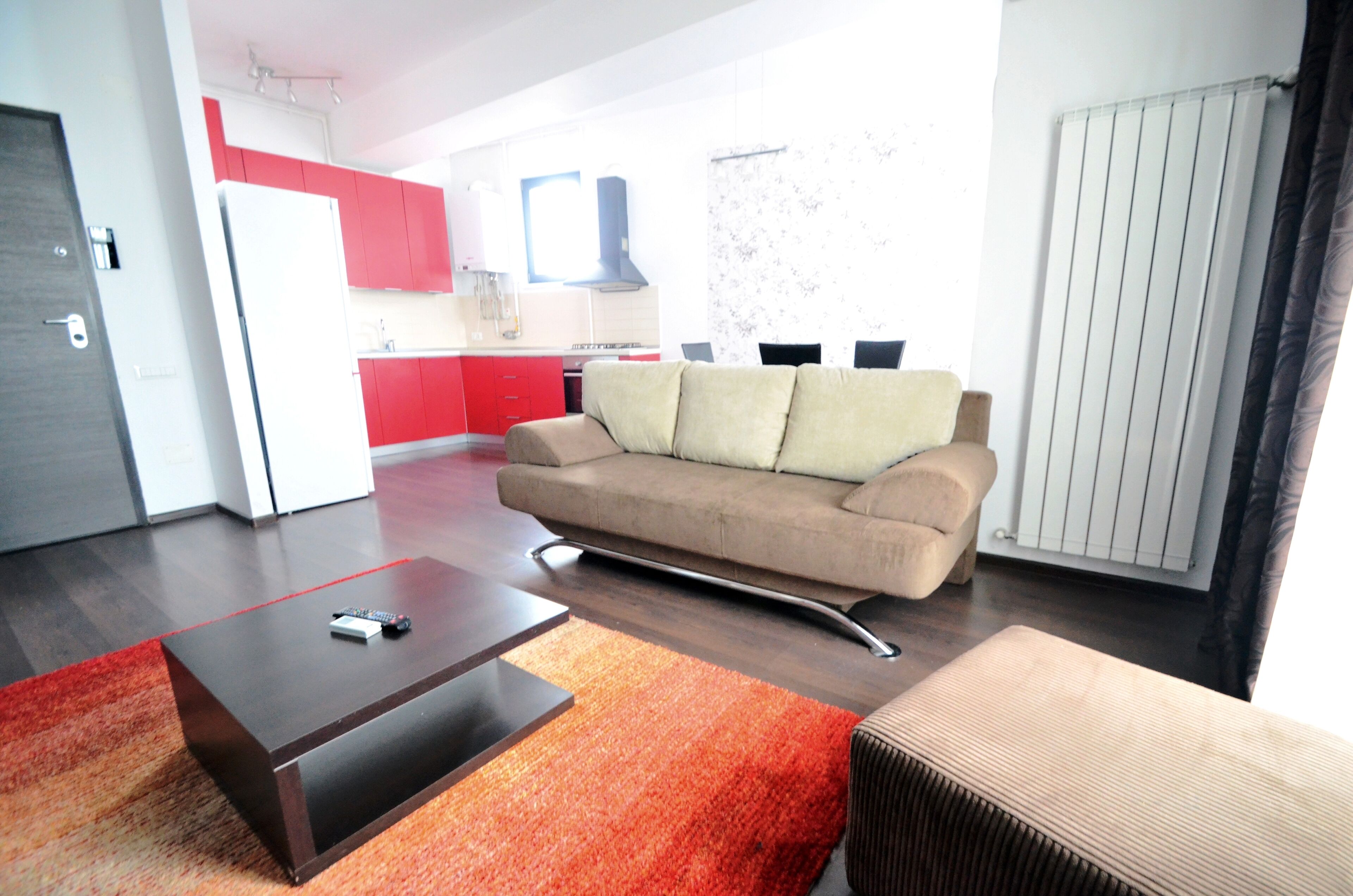 Una sala de estar moderna con un sofá, una mesita de centro y una cocina al fondo.