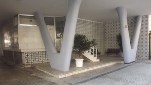 Een modern gebouw met een betegelde vloer, een trap en een potplant.