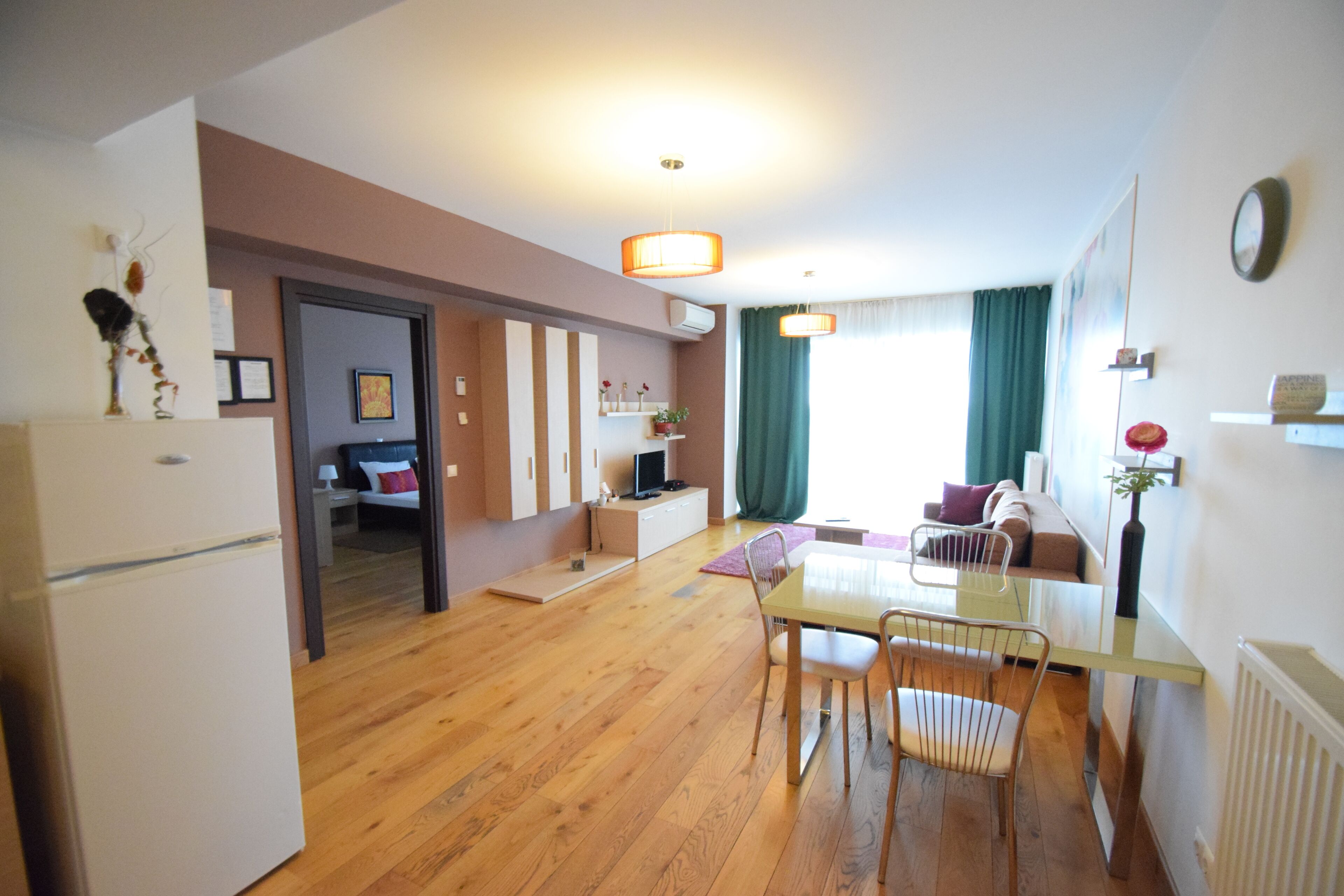 A modern apartment with a dining area, kitchen, and living space.