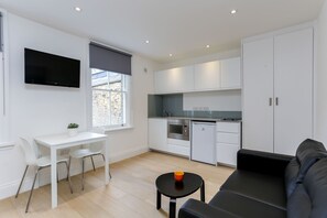 Cozy living space with a flat-screen TV, dining area, and kitchenette.