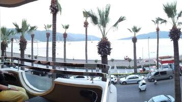 A balcony with a view of a beach and palm trees.