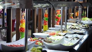 Un buffet proposant une variété de plats et une colonne décorative ornée de fruits.