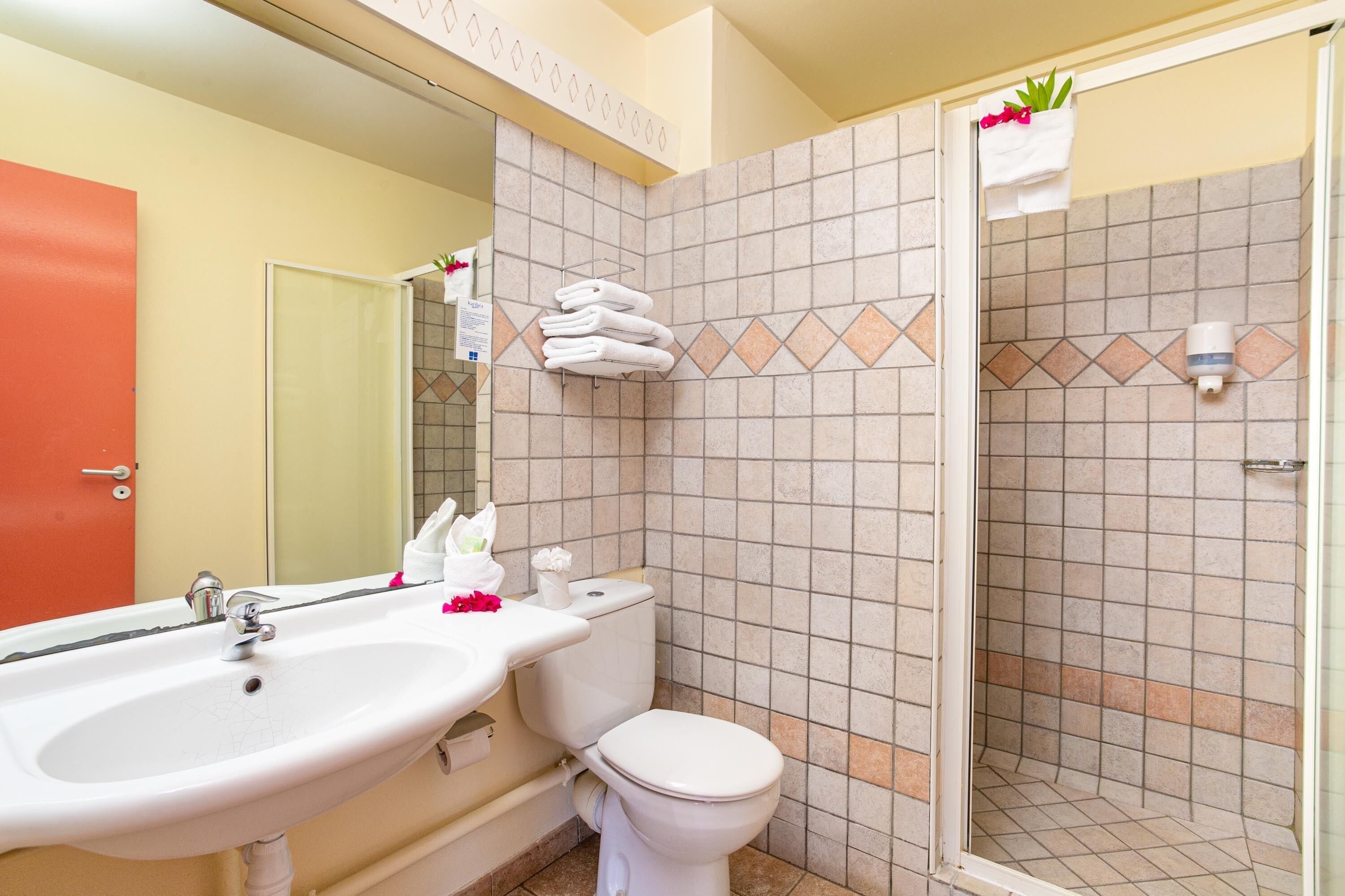 A bathroom with a sink, toilet, and shower.