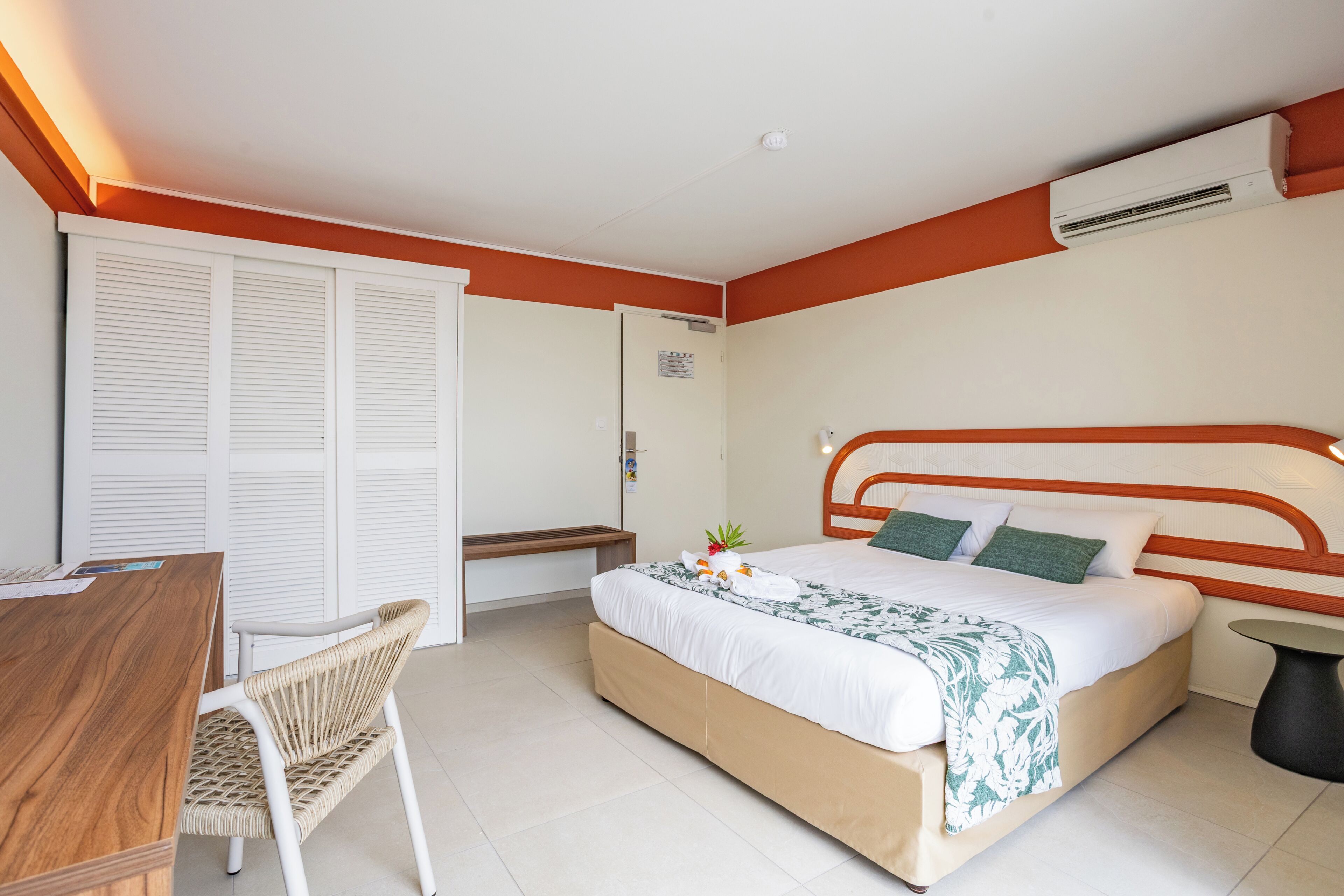 Una habitación de hotel con cama, escritorio, silla y baño.