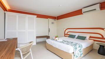 A hotel room with a bed, a desk, a chair, and a bathroom.