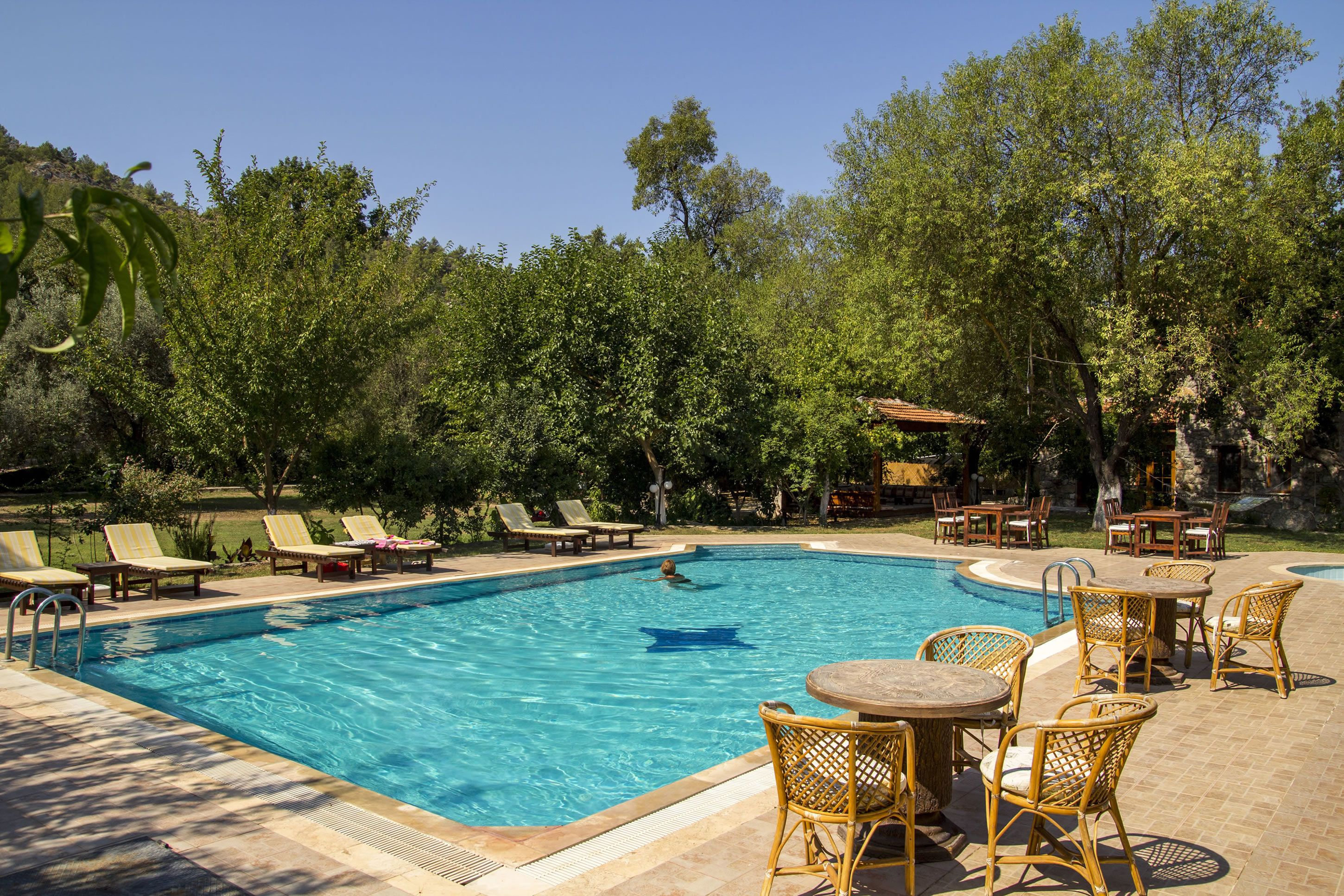 Una piscina al aire libre de temporada, sombrillas