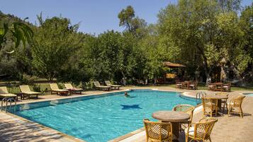 Una piscina al aire libre de temporada, sombrillas