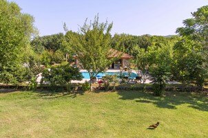 Una piscina al aire libre de temporada, sombrillas