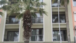 A multi-story hotel with balconies and palm trees in front. - Candan Beach Hotel (Marmaris)