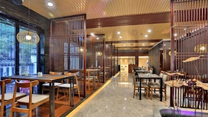 A restaurant with wooden furniture, a marble floor, and a view through a wooden partition. - Hiking Hotel Hangzhou (Hangzhou)