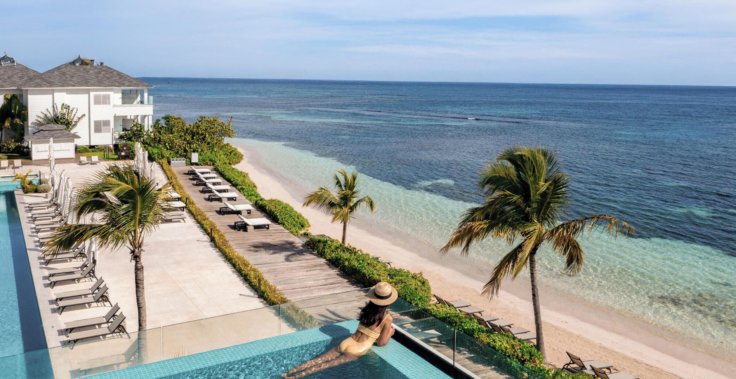 Un complexe hôtelier doté d’une piscine, d’une plage et offrant une vue sur l’océan.