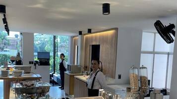 Una barra de desayuno moderna con diferentes alimentos y una máquina de café.