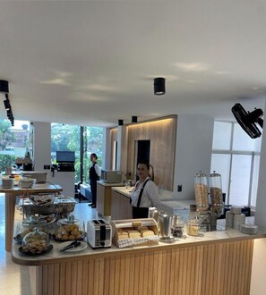 A modern breakfast bar with various food items and a coffee machine. - Hotel Santiago de Arma (Rionegro)