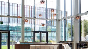 A spacious lobby with high ceilings and large windows, modern seating arrangements, and hanging pendant lights. - Hyatt Regency Manchester (Manchester)