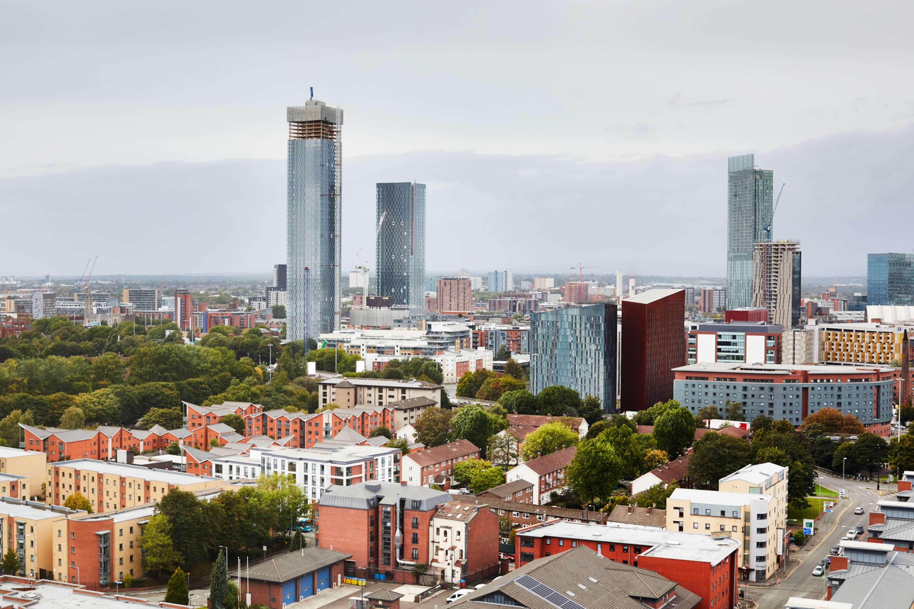 Eine Stadtansicht mit modernen Hochhäusern, einer Mischung aus Wohn- und Geschäftsgebäuden und einer dicht bebauten urbanen Umgebung.