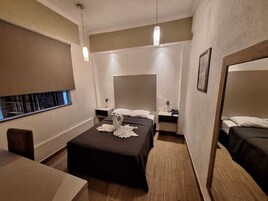 Een hotelkamer met een bed, nachtkastjes, een spiegel en een raam.